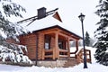 Wooden house in mountain in winter time. Log cabin in forest alone in wilderness. Wooden house with a wooden roof against Royalty Free Stock Photo