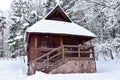 Wooden house in mountain in winter time. Log cabin in forest alone in wilderness. Wooden house with a wooden roof against Royalty Free Stock Photo