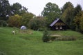 Wooden house in nature in the field. Country house with cow grazing in front and pond Royalty Free Stock Photo