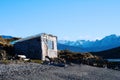 House on river with mountains at back. Royalty Free Stock Photo