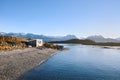 House on river with mountains at back. Royalty Free Stock Photo