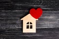 Wooden house with a red heart on a background of black wooden boards. A notification icon for the application. Love nest, love Royalty Free Stock Photo