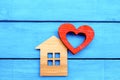 Wooden House And Red Heart On A Blue Wooden Background. Concept Of Love