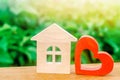 Wooden house and red heart. Concept of sweet home. Property insurance. Family comfort. Affordable housing for young families. Royalty Free Stock Photo