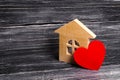 Wooden house with a red heart on a dark wooden background. A house for lovers, a honeymoon. Purchase your own affordable housing Royalty Free Stock Photo