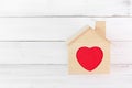 Wooden House with red heart outline in house over white wood background. Happy Family Concept with Copy Space