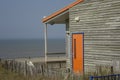 Wooden house at the shore with an orange door Royalty Free Stock Photo