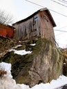 Wooden, house and snow on a cliff in Norway in winter weather for housing and living. Snowing, frozen and wood cabin