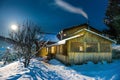 Wooden house in snow at winter night Royalty Free Stock Photo