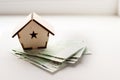 wooden house stands on a pile of paper bills euro as a symbol of mortgage Royalty Free Stock Photo
