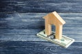 A wooden house stands on a stack of dolor banknotes. The concept of buying and selling immovability, rent of apartments. Credit an Royalty Free Stock Photo