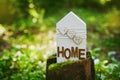 Wooden house stands on a tree stump in a green forest. Peace home, nature, eco or environmental protection concept. Royalty Free Stock Photo