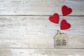 Wooden house with three red hearts on a wooden background. Love nest, love relationships. Buying a house with a young family. Royalty Free Stock Photo