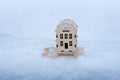 Wooden house on a toy sled in the snow, the concept of Christmas gifts, discounts on real estate, renting an apartment in winter, Royalty Free Stock Photo