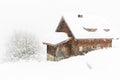 Wooden house and tree during snow fall