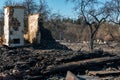 A wooden house in the village burned down because of a forest fire. Charred boards and various things lie on the ground, covered Royalty Free Stock Photo