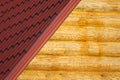 Wooden house wall and part of red roof from metal tile closeup Royalty Free Stock Photo
