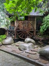 Wooden house with a waterwheel by the fish pond Royalty Free Stock Photo