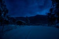 wooden house in winter forest. Mountain house in the snow at night. Misty night Royalty Free Stock Photo