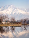 A wooden houseboat on the banks of the Dal Lake with snow covered Zabarwan Hills in the background in Srinagar, Kashmir Royalty Free Stock Photo