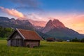 Wooden houses in the alpine ski town Garmisch-Partenkirchen captured against mountains at sunset Royalty Free Stock Photo