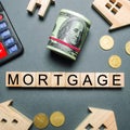 Wooden houses, a calculator, keys, coins and blocks with the word Mortgage. Buying a home in debt. Purchase a house on credit. Royalty Free Stock Photo