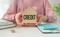 Wooden Houses and Credit word on wooden House in hands woman. Concept of credit for buying a new house