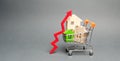 Wooden houses in a shopping cart and red arrow up. The concept of increasing the cost of housing. High demand for real estate. The Royalty Free Stock Photo