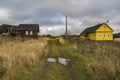 Wooden houses stand opposite each other along the village road.