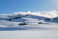 Wooden houses under snow in mountains, Spring in Norway, bright sunny day.