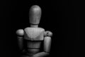 Wooden Human Manikin posing for an audience with a black background