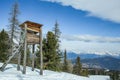 Wooden hunting tower in the winter forest in the mountains