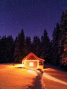 Wooden hut on the lawn covered with snow. Marry Christmas and New Year. The lamps light up the house at the evening time. Winter Royalty Free Stock Photo