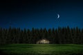 Wooden hut with a lighted window at night