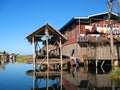 Wooden hut on stilts reflected in the waters of Inle Lake