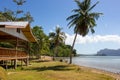 Wooden hut on tropical beach with palms and isles on background. Oriental house in beautiful lagoon. Summer vacation. Asian travel Royalty Free Stock Photo