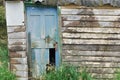 Wooden hut with weathered wooden broken door.