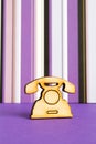 Wooden icon of telephone on purple striped background Royalty Free Stock Photo