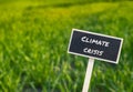 Wooden information label sign with text CLIMATE CRISIS against defocused agriculture field message. Global hunger Royalty Free Stock Photo