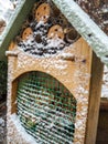 Wooden insect hotel covered in snow