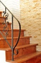 Wooden interior stairway with ornamental ironwork railing Royalty Free Stock Photo