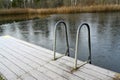 wooden jetty with bathing ladder on frozen lake