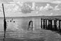 Wooden jetty for boats against a blue sky with some clouds. Floating buoys and fishing nets. Hills on background. Bolsena lake, Royalty Free Stock Photo