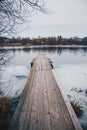 Wooden jetty on an early spring river with ice Royalty Free Stock Photo