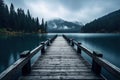 Wooden jetty over the mountain lake with forest on rainy cloudy gloomy day Royalty Free Stock Photo