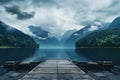 Wooden jetty over the mountain lake with forest on rainy cloudy gloomy day Royalty Free Stock Photo