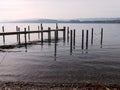 Wooden jetty and posts on the shores of the Lake Murten Royalty Free Stock Photo