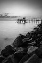 wooden Jetty with the rocky seaside during sunset. Vertical Orientation Black and White Royalty Free Stock Photo