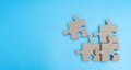 Wooden Jigsaw Puzzle parts on blue background. four puzzles form a rectangle on blue background. Wide view Royalty Free Stock Photo