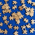 Wooden jigsaw puzzle pieces scattered on a vibrant blue surface Royalty Free Stock Photo